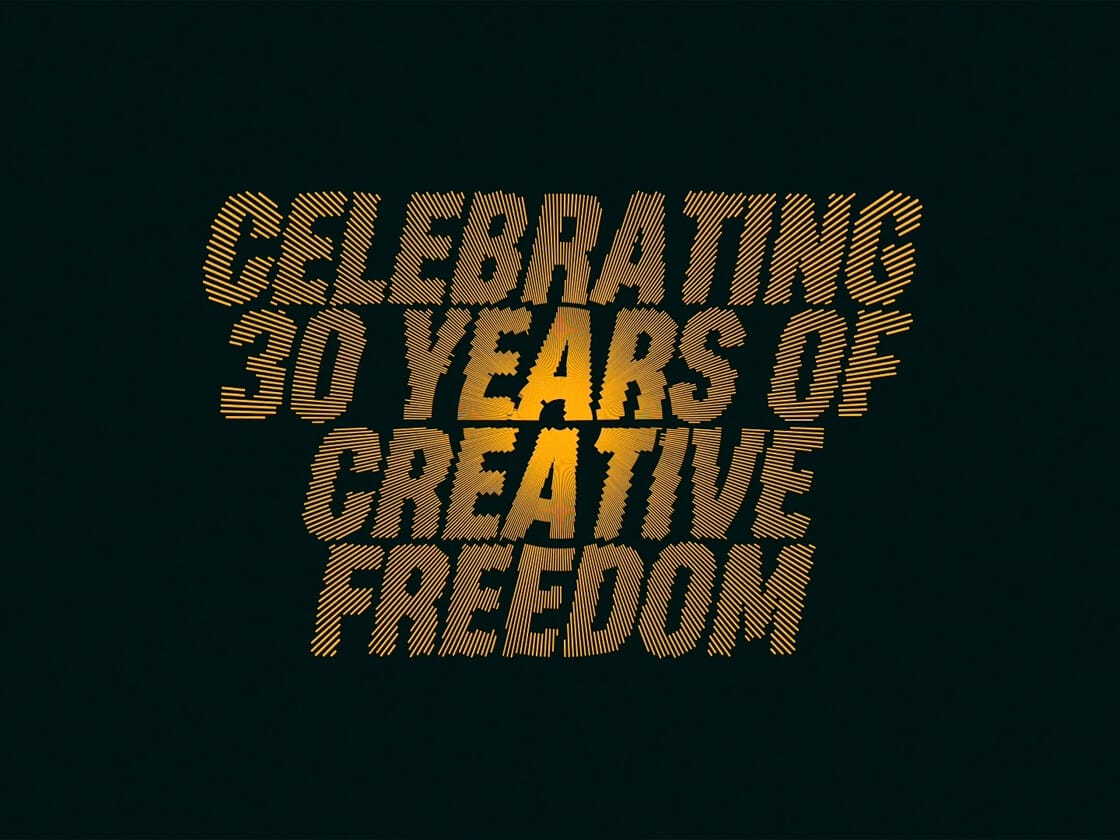 Celebrating 30 Years of Creative Freedom" is written in bold, yellow, diagonal striped text against a dark green background, with a glowing effect behind the words in a looped video that captures the essence of Basha Uhuru.